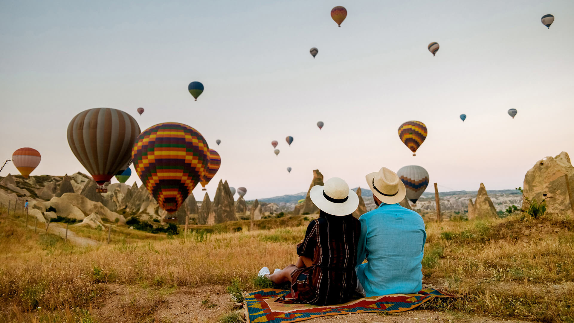 Une nuée de montgolfières observée par un couple