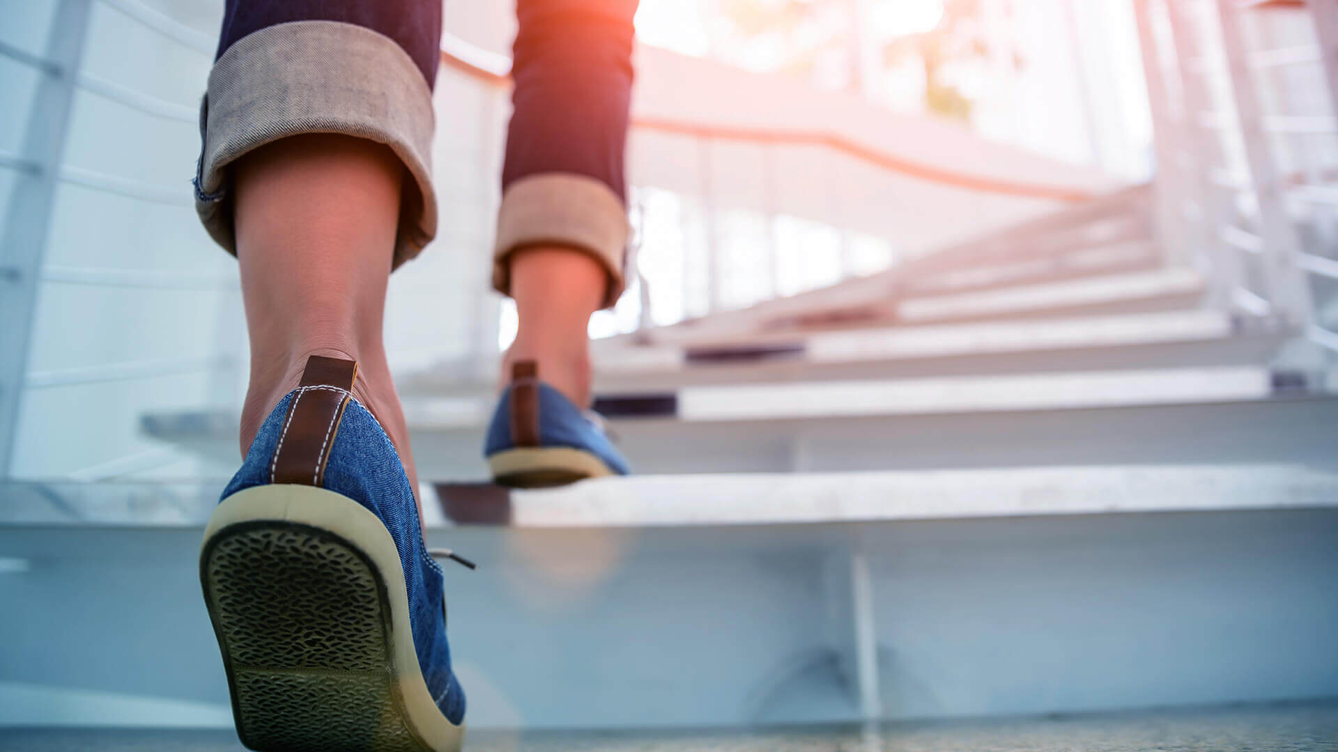 Deux jambes gravissent les marches d'un escalier