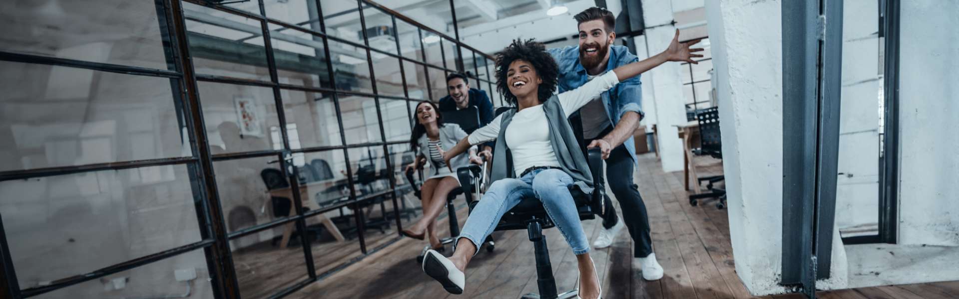 Des collègues sur une chaise poussés par d'autres et qui s'amusent ensembles